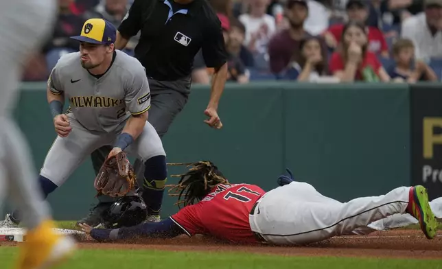 Cleveland Guardians' Jose Ramirez, right, steals third base as Milwaukee Brewers third baseman Caleb Durbin, left, waits for the throw in the fourth inning of a baseball game in Cleveland, Monday, May 12, 2025. (AP Photo/Sue Ogrocki)