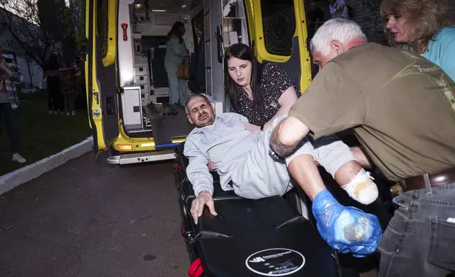 An injured Ukrainian soldier who was a prisoner of war is placed on a stretcher after being returned to his home country by Russia, April. 19, 2025. (AP Photo/Evgeniy Maloletka)