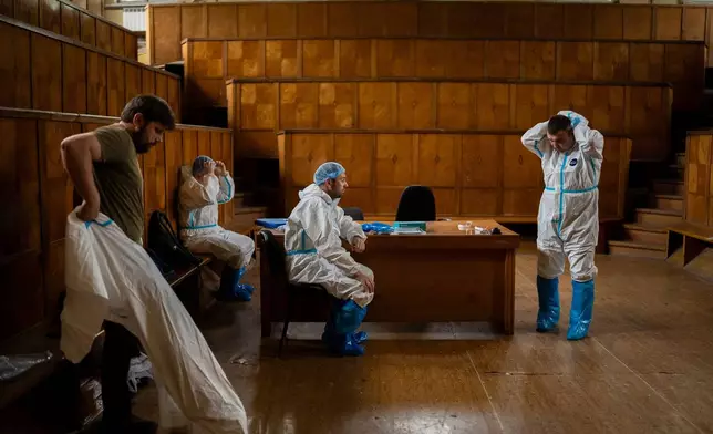 Workers change clothes at a morgue in Kyiv, Ukraine, June 24, 2024. (AP Photo/Alex Babenko)