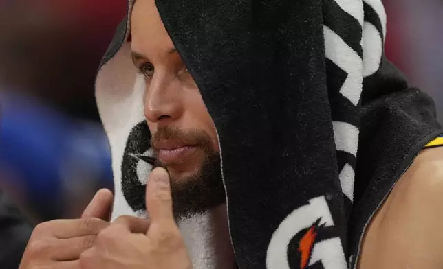 Golden State Warriors guard Stephen Curry watches from the bench during the second half of Game 5 of an NBA basketball first-round playoff series against the Houston Rockets, Wednesday, April 30, 2025, in Houston. (AP Photo/David J. Phillip)