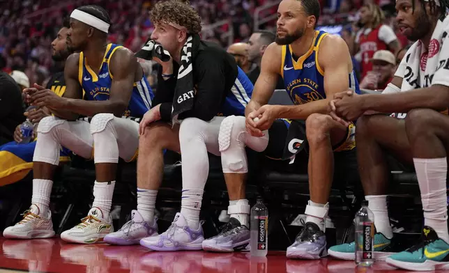 From left; Golden State Warriors forward Jimmy Butler III, guard Brandin Podziemski and guard Stephen Curry (30) sit on the bench during the second half of Game 5 of an NBA basketball first-round playoff series against the Houston Rockets, Wednesday, April 30, 2025, in Houston. (AP Photo/David J. Phillip)