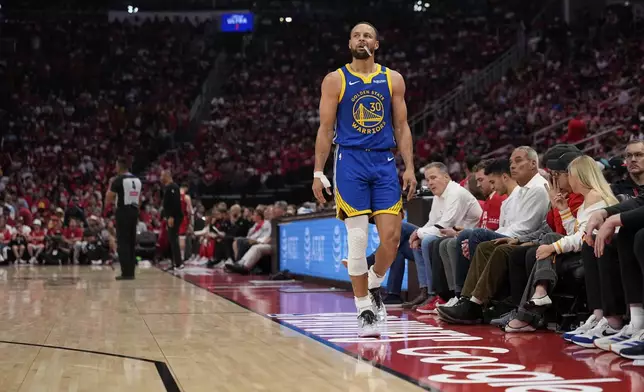 Golden State Warriors guard Stephen Curry (30) watches from the sidelines during the first half of Game 5 of an NBA basketball first-round playoff series against the Houston Rockets, Wednesday, April 30, 2025, in Houston. (AP Photo/David J. Phillip)
