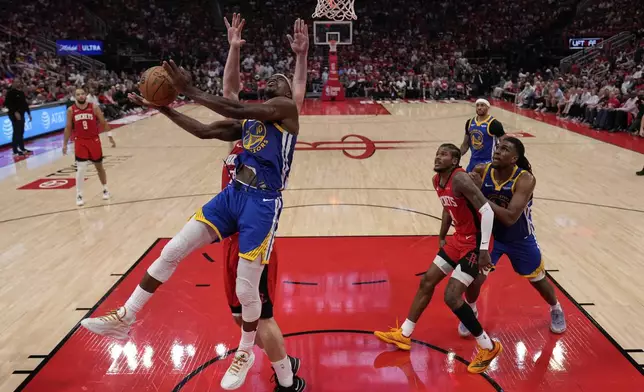 Golden State Warriors forward Jimmy Butler III (10) shoots around Houston Rockets center Alperen Sengun during the first half of Game 5 of an NBA basketball first-round playoff series, Wednesday, April 30, 2024, in Houston. (AP Photo/David J. Phillip)