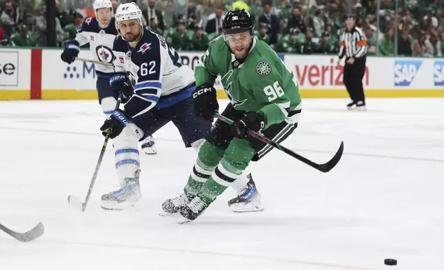 Dallas Stars right wing Mikko Rantanen (96) and Winnipeg Jets right wing Nino Niederreiter (62) compete for control of the puck in the first period of Game 4 of a second-round NHL hockey playoff series in Dallas, Tuesday, May 13, 2025. (AP Photo/Gareth Patterson)
