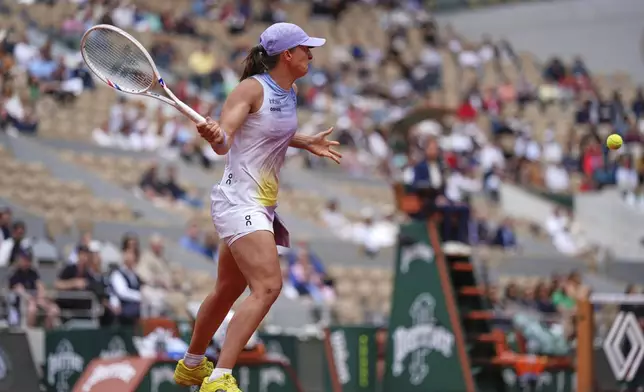 Poland's Iga Swiatek returns the ball to Slovakia's Rebecca Sramkova during their first round match of the French Tennis Open, at the Roland-Garros stadium, in Paris, Monday, May 26, 2025. (AP Photo/Lindsey Wasson)