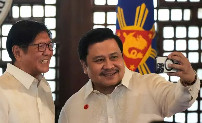 Philippine President Ferdinand Marcos Jr., left, poses for a selfie with Senator Jinggoy Estrada after the presentation of the newly enacted laws to stakeholders at the Malacanang Presidential Palace in Manila, Philippines Thursday, May 22, 2025. (AP Photo/Aaron Favila)