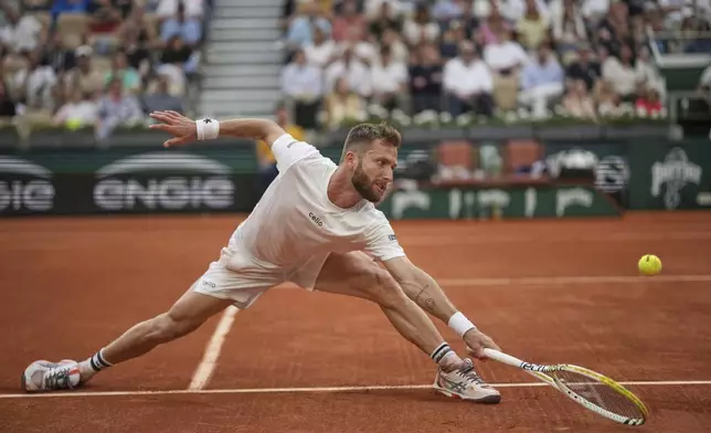 France's Corentin Moutet reaches for the ball as he plays Serbia's Novak Djokovic during their second round match of the French Tennis Open, at the Roland-Garros stadium, in Paris, Thursday, May 29, 2025. (AP Photo/Christophe Ena)