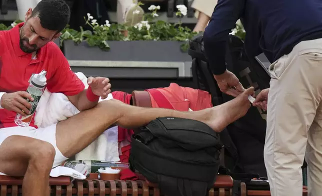 Serbia's Novak Djokovic receives medical assistance during his second round match of the French Tennis Open against France's Corentin Moutet, at the Roland-Garros stadium, in Paris, Thursday, May 29, 2025. (AP Photo/Christophe Ena)