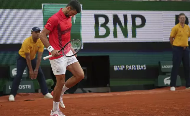 Serbia's Novak Djokovic limps on the court before receiving medical assistance during his second round match of the French Tennis Open against France's Corentin Moutet, at the Roland-Garros stadium, in Paris, Thursday, May 29, 2025. (AP Photo/Christophe Ena)