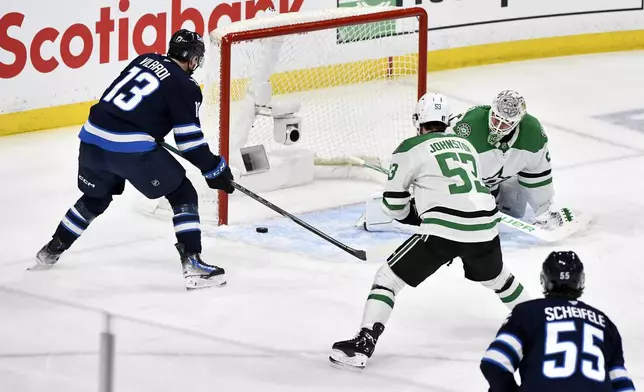 Winnipeg Jets' Gabriel Vilardi (13) scores against Dallas Stars goaltender Jake Oettinger, top right, during the first period of Game 2 of a second-round NHL hockey playoff series in Winnipeg, Manitoba, Friday, May 9, 2025. (Fred Greenslade/The Canadian Press via AP)
