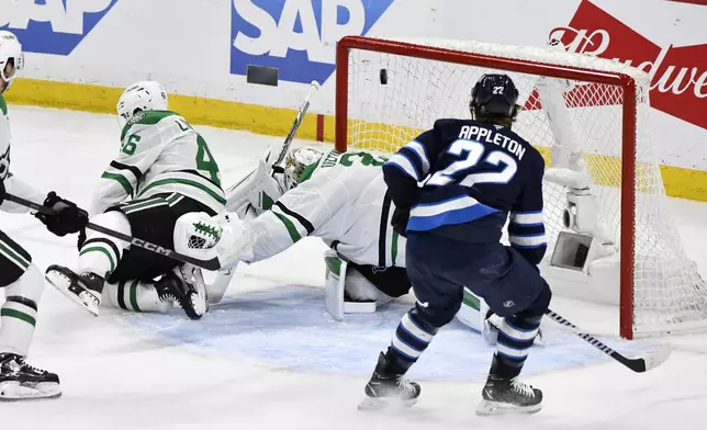 A shot by Winnipeg Jets' Adam Lowry (not shown) gets past Dallas Stars goaltender Jake Oettinger (29) for a goal during second period NHL playoff hockey action in Winnipeg, Friday, May 9, 2025. (Fred Greenslade/The Canadian Press via AP)