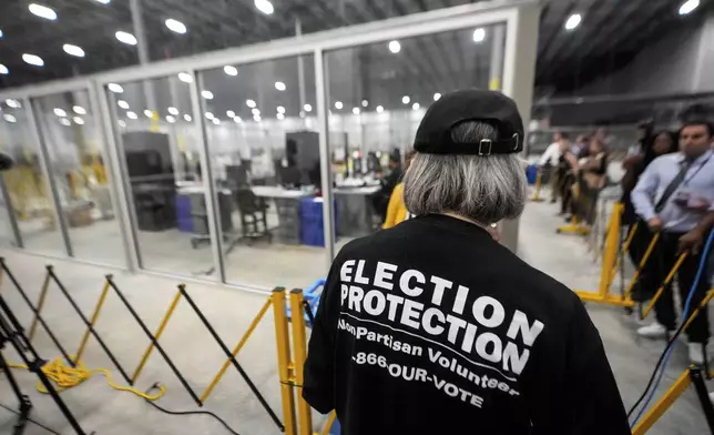 FILE - A non-partisan election volunteer observes as memory cards are uploaded from early voting at the Fulton County Election Hub and Operation Center, Nov. 5, 2024, in Atlanta, Mo. (AP Photo/John Bazemore, File)