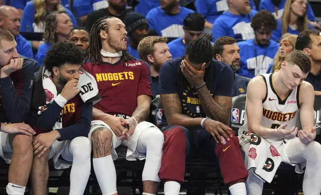 Denver Nuggets' Nikola Jokic, from left, Jamal Murray, Aaron Gordon, DeAndre Jordan and Christian Braun, right, sit on the bench watching play against the Oklahoma City Thunder late in the second half of Game 7 in the Western Conference semifinals of the NBA basketball playoffs, Sunday, May 18, 2025, in Oklahoma City. (AP Photo/Kyle Phillips)