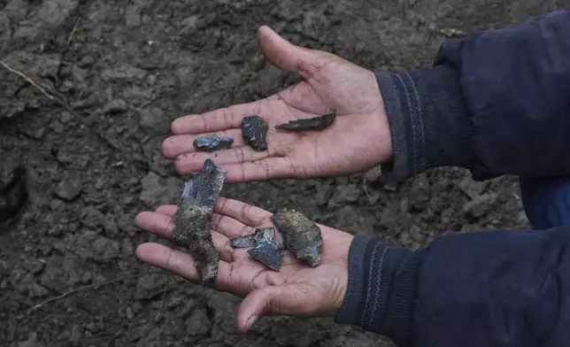 Kashmiri villager Mohammad Rafiq displays shrapnel of a shell as he sits near a crater outside his damaged house following overnight shelling from Pakistan at Gingal village in Uri district, Indian controlled Kashmir, Friday, May 9, 2025. (AP Photo/Dar Yasin)