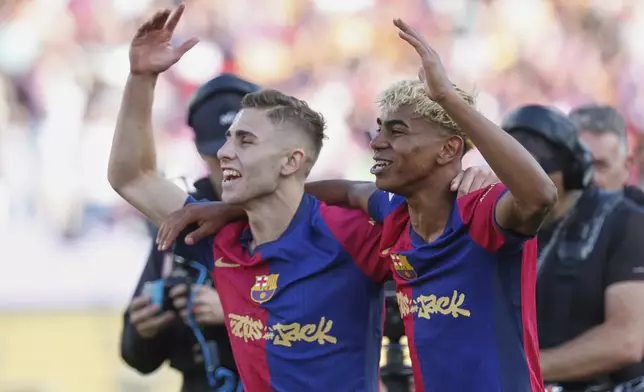 Barcelona's Fermin Lopez, left, and Lamine Yamal celebrate after the La Liga soccer match between Barcelona and Real Madrid in Barcelona, Spain, Sunday, May 11, 2025. AP Photo/Joan Monfort)