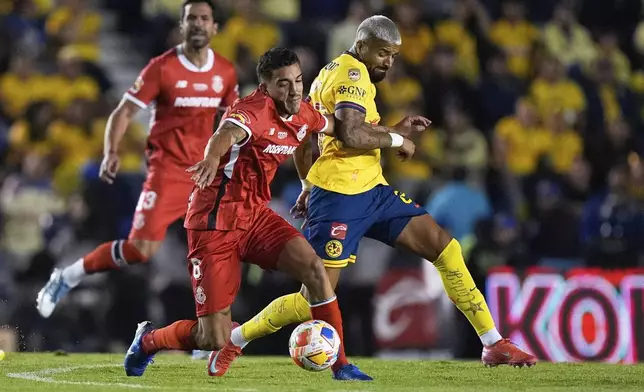 America's Rodrigo Aguirre, right, and Toluca's Andres Pereira fight for the ball during the Mexican soccer league first leg final match in Mexico City, Thursday, May 22, 2025. (AP Photo/Fernando Llano)