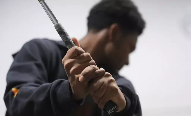 Shaun Horne, 16, a junior at Renaissance High School practices his golf swing in Detroit, Thursday, Feb. 27, 2025. (AP Photo/Paul Sancya)