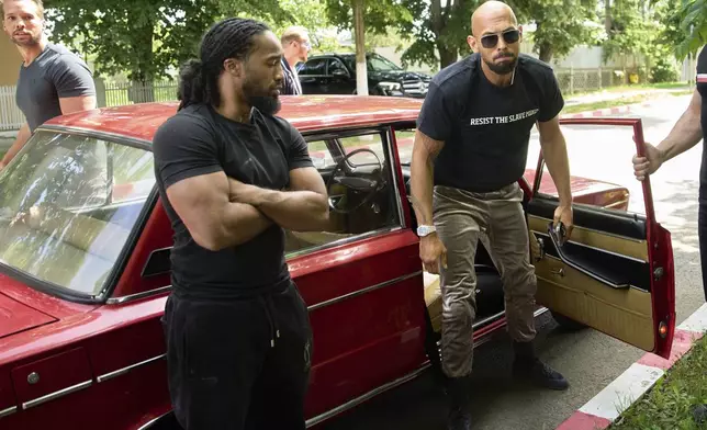 Andrew Tate and his brother Tristan, top left, arrives at a police station in a Lada vehicle in Voluntari, Romania, Wednesday, May 21, 2025. (AP Photo/Vadim Ghirda)
