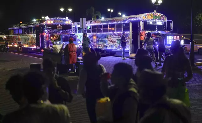People wait to board a Red Devil party bus in Panama City, Saturday, May 17, 2025. (AP Photo/Matias Delacroix)