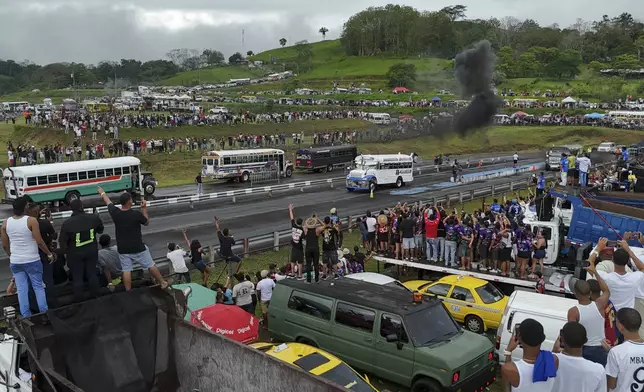 Spectators watch Red Devil buses race at a track in La Chorrera, Panama, Sunday, May 18, 2025. Red Devils are former U.S. school buses once used in the Panama Canal Zone, later repurposed as public transport or adapted for private and cultural use. (AP Photo/Matias Delacroix)