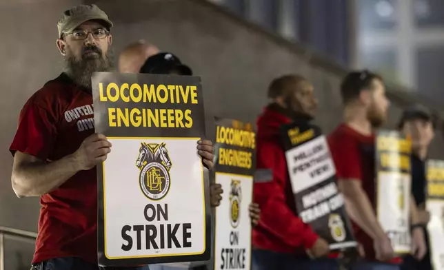 Union members from the Brotherhood of Locomotive Engineers and Trainmen form a picket line outside the NJ Transit Headquarters on Friday, May 16, 2025 in Newark, New Jersey. (AP Photo/Stefan Jeremiah)