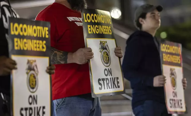 Union members from the Brotherhood of Locomotive Engineers and Trainmen form a picket line outside the NJ Transit Headquarters on Friday, May 16, 2025 in Newark, New Jersey. (AP Photo/Stefan Jeremiah)
