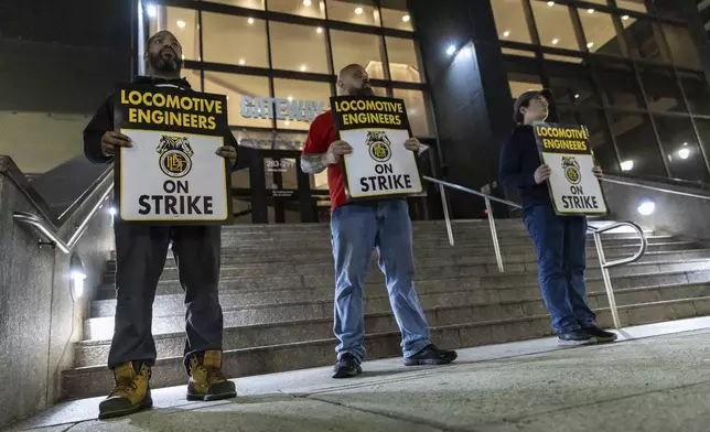 Union members from the Brotherhood of Locomotive Engineers and Trainmen form a picket line outside the NJ Transit Headquarters on Friday, May 16, 2025 in Newark, New Jersey. (AP Photo/Stefan Jeremiah)