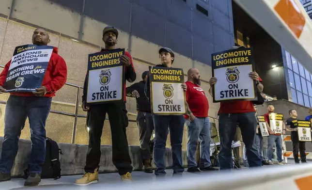 Union members from the Brotherhood of Locomotive Engineers and Trainmen form a picket line outside the NJ Transit Headquarters on Friday, May 16, 2025 in Newark, New Jersey. (AP Photo/Stefan Jeremiah)