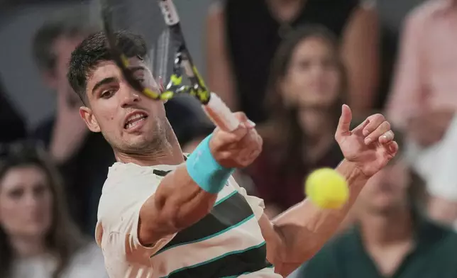 Spain's Carlos Alcaraz returns the ball to Bosnia and Herzegovina's Damir Dzumhur during their third round match at the French Open tennis tournament at the Roland-Garros stadium, Friday, May 30, 2025, in Paris. (AP Photo/Thibault Camus)