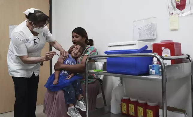 A health worker gives a child a measles vaccine at the health center in Ciudad Juarez, Chihuahua state, Mexico, Wednesday, April 30, 2025. (AP Photo/Christian Chavez)