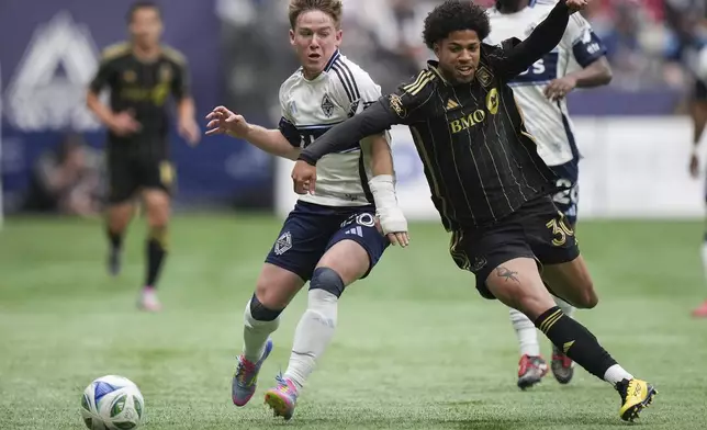 Vancouver Whitecaps' Tate Johnson, left, and Los Angeles FC's David Martinez, front right, vie for the ball during the first half of an MLS soccer match in Vancouver, British Columbia, Sunday, May 11, 2025. (Darryl Dyck/The Canadian Press via AP)