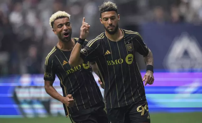 Los Angeles FC's Denis Bouanga, right, and Timothy Tillman, left, celebrate after Bouanga's penalty kick goal against the Vancouver Whitecaps during the first half of an MLS soccer match in Vancouver, British Columbia, Sunday, May 11, 2025. (Darryl Dyck/The Canadian Press via AP)