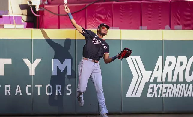 Washington Nationals outfielder James Wood throws after making a catch at the wall in the first inning of a baseball game against the Atlanta Braves, Monday, May 12, 2025, in Atlanta. (AP Photo/Colin Hubbard)