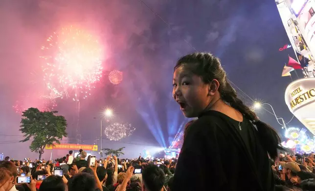 A girl watches a fireworks display during the celebrations of the 50th anniversary of the end of the Vietnam War in Ho Chi Minh City, Vietnam, Wednesday, April 30, 2025. (AP Photo/Achmad Ibrahim)