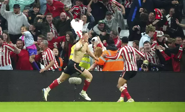 Sunderland's Daniel Ballard (5) celebrates scoring the winning goal against against Coventry during extra time in a Sky Bet Championship play-off semifinal, second leg soccer match at the Stadium of Light, Tuesday May 13, 2025, in Sunderland, England. (Owen Humphreys/PA via AP)