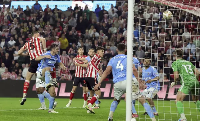 Sunderland's Daniel Ballard (5) scores their side's first goal of the game against Coventry during extra time in a Sky Bet Championship play-off semifinal, second leg soccer match at the Stadium of Light, Tuesday May 13, 2025, in Sunderland, England. (Steve Welsh/PA via AP)