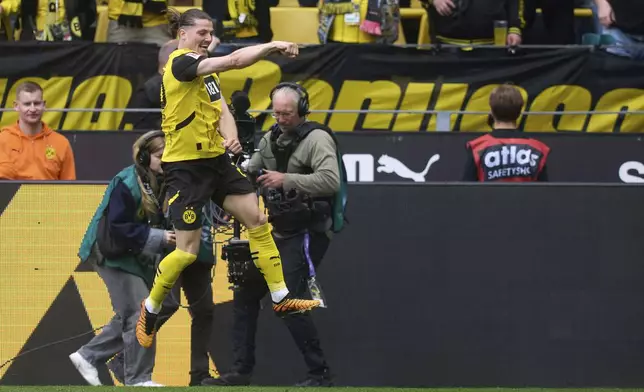 Dortmund's Marcel Sabitzer celebrates after scoring during the German Bundesliga soccer match between Borussia Dortmund and Holstein Kiel at Signal Iduna Park in Dortmund, Germany, Saturday, May 17, 2025. (Bernd Thissen/dpa via AP)