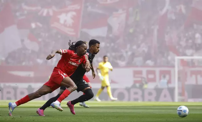 Freiburg's Jordy Makengo, front, and Frankfurt's Ansgar Knauff fight for the ball during the German Bundesliga soccer match between SC Freiburg and Eintracht Frankfurt at the Europa-Park Stadium in Freiburg im Breisgau, Germany, Saturday, May 17, 2025. (Philipp von Ditfurth/dpa via AP)
