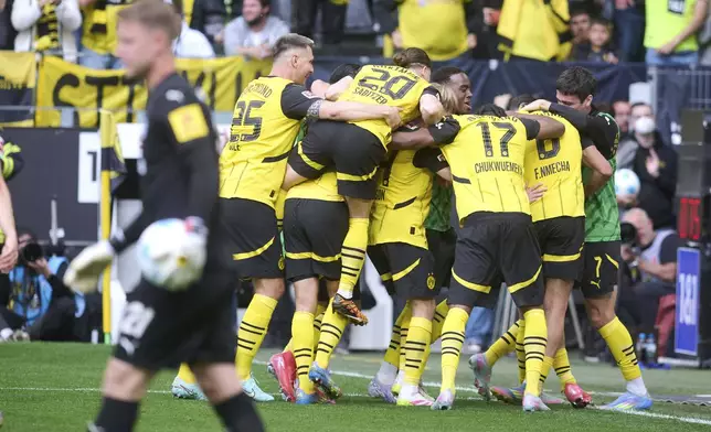 Dortmund's Felix Nmecha, center obscured, celebrates scoring during the German Bundesliga soccer match between Borussia Dortmund and Holstein Kiel at Signal Iduna Park in Dortmund, Germany, Saturday, May 17, 2025. (Bernd Thissen/dpa via AP)