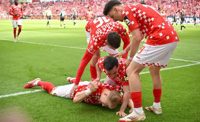 Mainz's Andreas Hanche-Olsen celebrates with his teammates after scoring a goal that was later disallowed, during the German Bundesliga soccer match between 1. FSV Mainz 05 and Bayer Leverkusen, at the Mewa Arena, in Mainz, Germany, Saturday, May 17, 2025. (Torsten Silz/dpa via AP)
