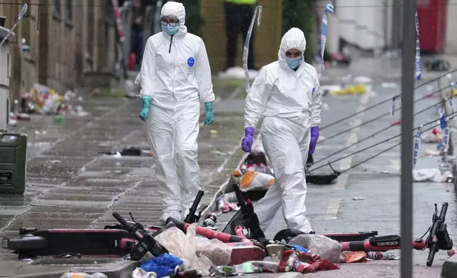 Forensic officers examine the site where a 53-year-old British man plowed a minivan into a crowd of Liverpool soccer fans who were celebrating the city's Premier League championship Monday, injuring more than 45 people in Liverpool, England, Tuesday, May 27, 2025. (AP Photo/Jon Super)
