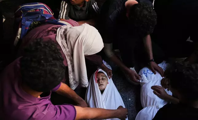 Mourners gather around the body of Palestinian child Ghazwane Hamdan,10, killed in an Israeli army airstrike, and brought to the Baptist Hospital in Gaza City, Monday, May 26, 2025. (AP Photo/Jehad Alshrafi)
