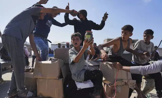 Palestinians carry boxes containing food and humanitarian aid packages delivered by the Gaza Humanitarian Foundation, a U.S.-backed organization approved by Israel, in Rafah, southern Gaza Strip, Tuesday, May 27, 2025. (AP Photo/Abdel Kareem Hana)