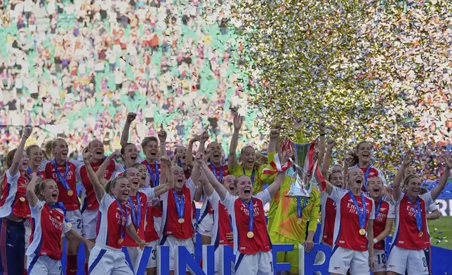 Arsenal players celebrate with their trophy after winning the women's Champions League final soccer match between Arsenal and FC Barcelona at the Jose Alvalade stadium in Lisbon, Saturday, May 24, 2025. (AP Photo/Armando Franca)