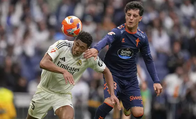 Real Madrid's Jude Bellingham, left, heads the ball ahead of Celta's Hugo Alvarez during the Spanish La Liga soccer match between Real Madrid and Celta Vigo at the Santiago Bernabeu stadium in Madrid, Spain, Sunday, May 4, 2025. (AP Photo/Jose Breton)