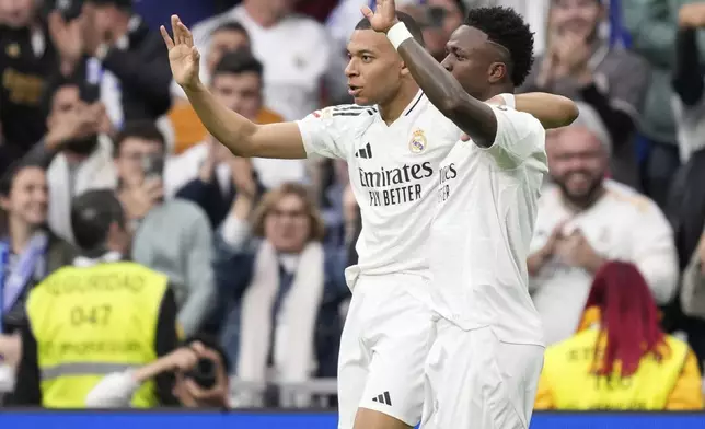 Real Madrid's Kylian Mbappe, left, celebrates with Vinicius Junior after scoring his side's third goal during the Spanish La Liga soccer match between Real Madrid and Celta Vigo at the Santiago Bernabeu stadium in Madrid, Spain, Sunday, May 4, 2025. (AP Photo/Jose Breton)