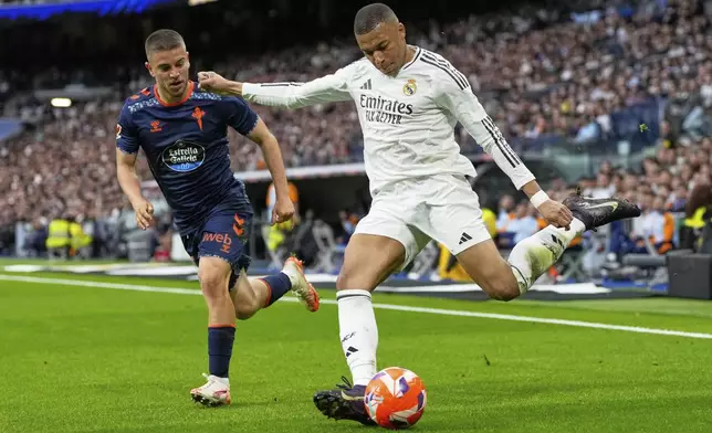Real Madrid's Kylian Mbappe, right, makes an attempt to score during the Spanish La Liga soccer match between Real Madrid and Celta Vigo at the Santiago Bernabeu stadium in Madrid, Spain, Sunday, May 4, 2025. (AP Photo/Jose Breton)