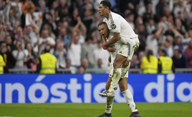 Real Madrid's Kylian Mbappe celebrates with Jude Bellingham after scoring his side's second goal during the Spanish La Liga soccer match between Real Madrid and Celta Vigo at the Santiago Bernabeu stadium in Madrid, Spain, Sunday, May 4, 2025. (AP Photo/Jose Breton)