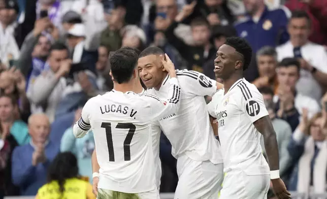 Real Madrid's Kylian Mbappe, centre, celebrates with teammates after scoring his side's third goal during the Spanish La Liga soccer match between Real Madrid and Celta Vigo at the Santiago Bernabeu stadium in Madrid, Spain, Sunday, May 4, 2025. (AP Photo/Jose Breton)