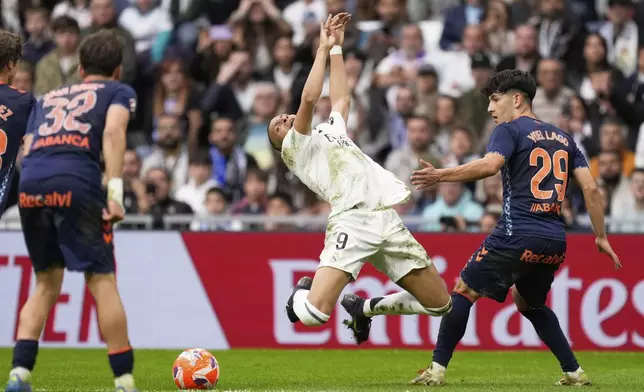 Real Madrid's Kylian Mbappe, centre, and Celta's Yoel Lago, right, in action during the Spanish La Liga soccer match between Real Madrid and Celta Vigo at the Santiago Bernabeu stadium in Madrid, Spain, Sunday, May 4, 2025. (AP Photo/Jose Breton)